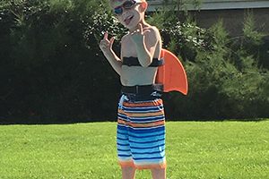 Child wearing SwimFin Swimming Aid at Poolside